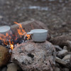 Kåsa i keramik bredvid öppen eld utomhus