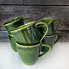 Keramikmugg i djup grön glasyr med prickar från Roslagen