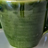 Keramikmugg i djup grön glasyr med prickar från Roslagen
